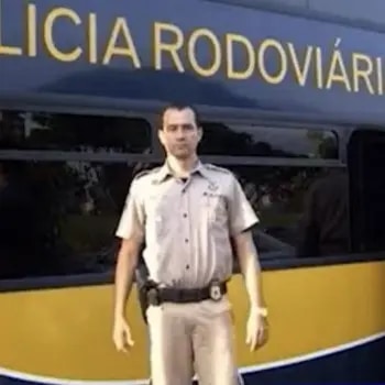 Marcelo Lessa uniformizado diante de uma viatura da Polícia Rodoviária Federal